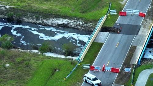 Aerial View of Police Patroling Damaged Road Bridge Over River After Flood Water Washed Away Asphalt