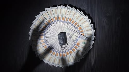 Dollars Stacked in a Circle Shadows of Hands Trying to Take the Key