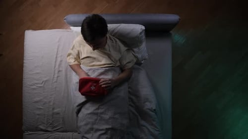 Man in Bed with First Aid Kit