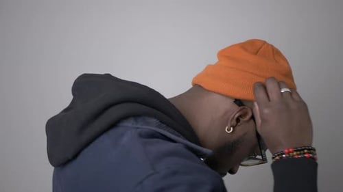 Cool Young Man Adjusting Orange Beanie