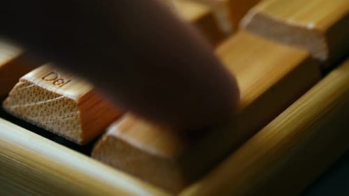Person Pressing Enter Key on Bamboo Keyboard
