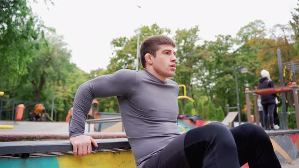 Man Doing Push Ups on Railing Under Tree in Park for Leisure and Fun ...