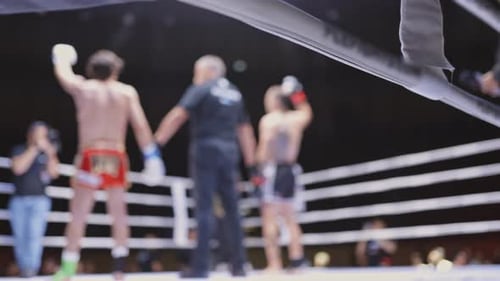 A Man is Holding His Hand Up in the Air in a Boxing Ring