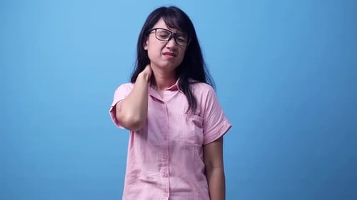 Woman Rubbing Aching Neck in Studio