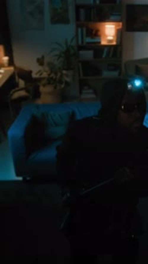 Adults in Ski Masks Hold Flashlights in Dark Home