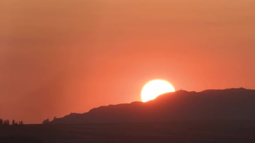 Orange Sun going down behind Hill