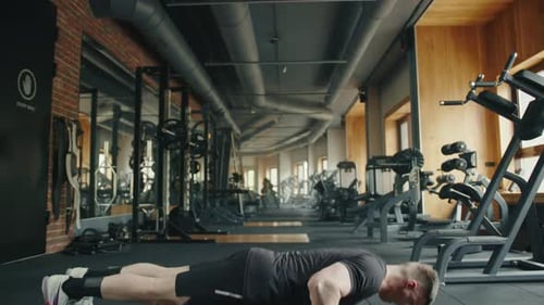 Young Fit Sportsman Exercises in Fullyequipped Gym Performing Pushups