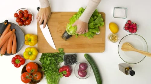 Healthy Eating, Vegetarian Food and Cooking Concept - Woman Adding Lettuce To