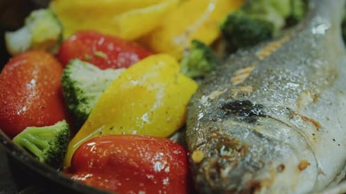 Close-Up of Fish with Vegetables Being Cooked in Frying Pan