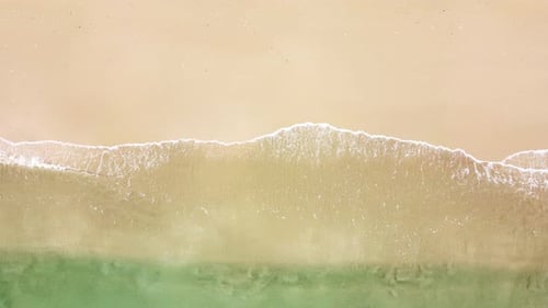 Sea wave on a sandy beach. Aerial view of a tropical beach with ocean waves.