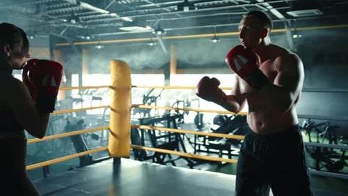 Man and Woman Boxing Training in Gym Ring