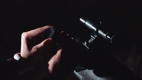 Close up of hands attaching lens to telescope
