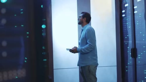 Man Inspecting Data in Data Center with Tablet