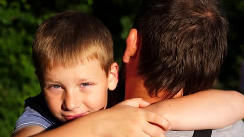 Boy Embracing His Father in a Close Up Shot