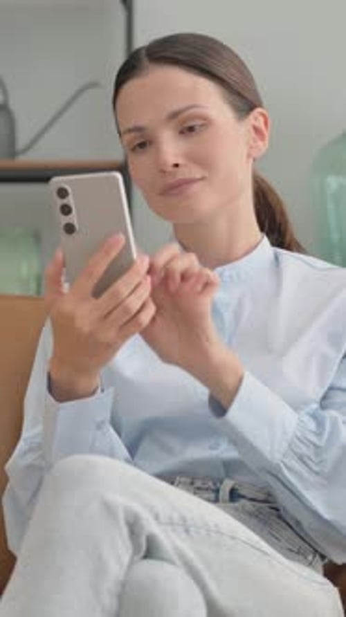 Woman Using Mobile Phone Indoors in Natural Light