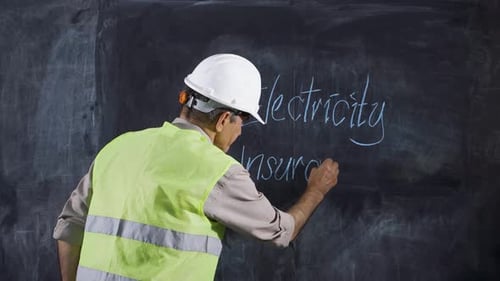 Man Writing Electricity Insurance on Chalkboard