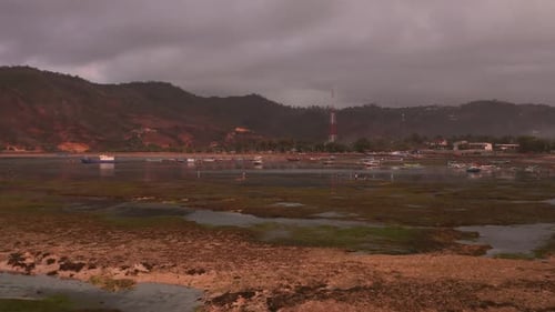 O recife seco de Kuta Lombok durante o nascer do sol, com a população local procurando comida e conchas marinhas. Aéreo
