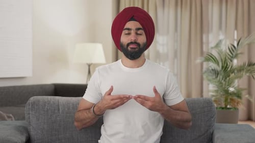 Man in Turban Sitting on Couch Talking