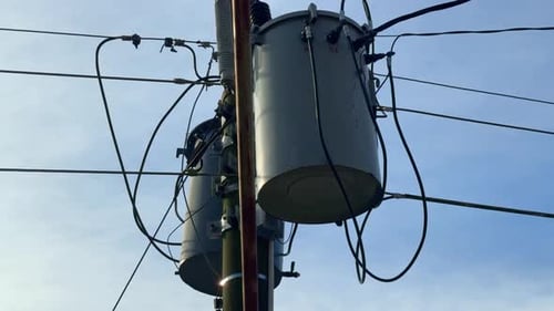 Hochspannungstransformatoren und Elektrokabel an einem Strommast,