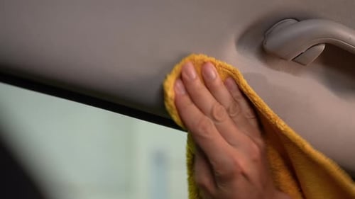 Closeup of Auto Service Man Applying Detergents to a Car Interior and Cleaning Surfaces with