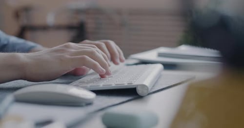 Hands Typing on Modern Keyboard at Desk