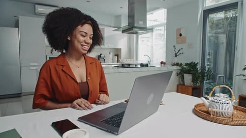 Woman Chatting on Laptop in Kitchen