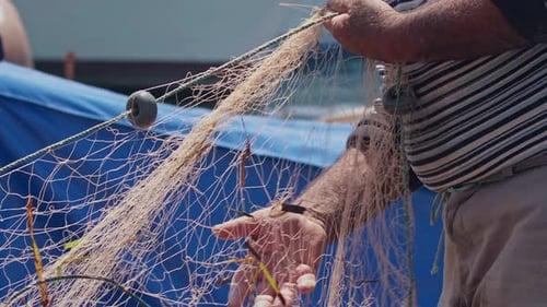Handarbeit älterer Fischer beim Reparieren ihrer Netze im Hafen 1
