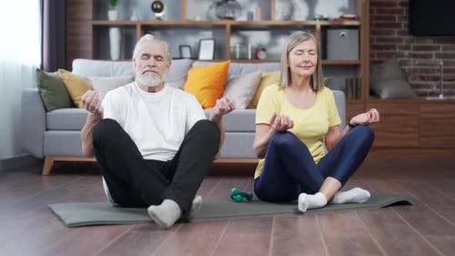 Mature Couple Meditating Together at Home