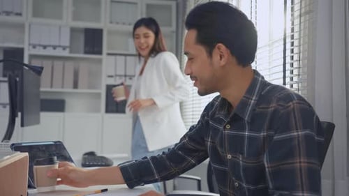 Young attractive businessman and businesswoman work in office workplace.