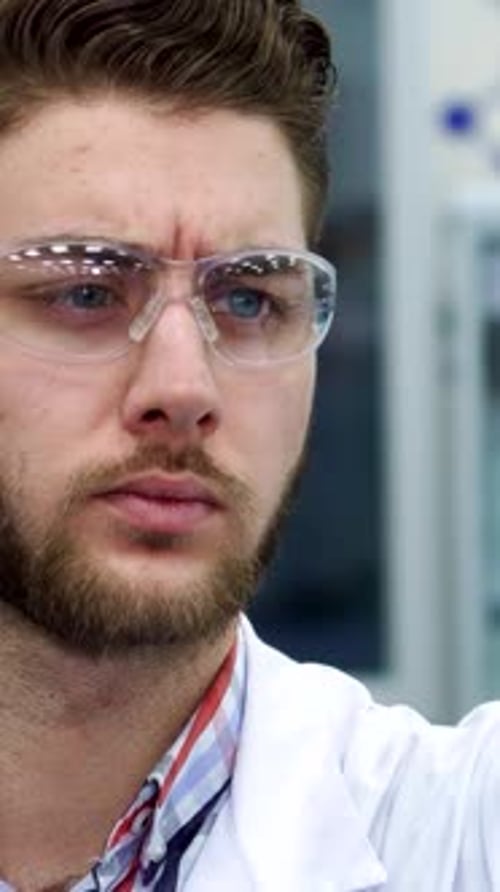 Young Adult Scientist Examining Test Tube in Lab