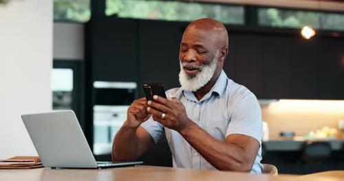 Man Using Smartphone While Sitting at Table