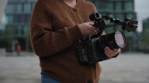 Person Holding Professional Video Camera in City