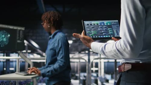 Data Center Admin Checking Code on Tablet Next to Colleague