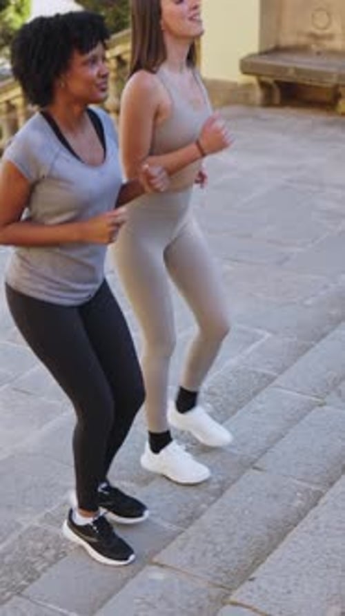 Women Running Up Stone Steps in City Park