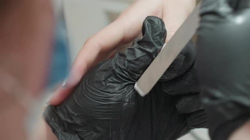 Manicurist Filing Client's Nails with Detail