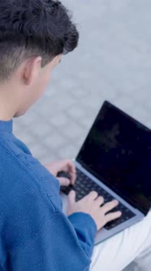 Young Adult Types on Laptop Outdoors