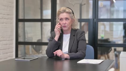 Senior Old Business Woman Talking on phone in Office