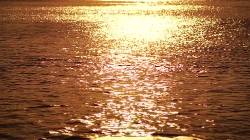 Blurred Golden Sea at Sunset The Sun Reflects and Sparkles on the Waves with Bokeh Illuminating the