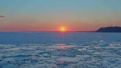 Aerial View of Sunset Over the Frozen Winter Sea Drone Flies Forward to Sunrise and Horizon Copter