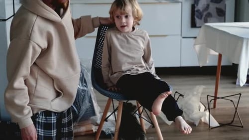 Happy Child Interacts With Adult in Kitchen