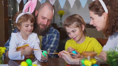 Family Painting Easter Eggs Together at Home