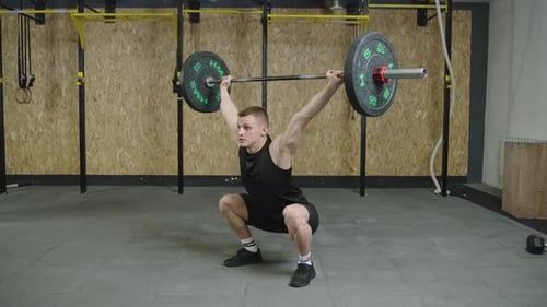 Man lifting barbell in gym during strength training session for fitness and health improvement