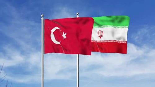 Turkey and Iran Flags Waving Against Blue Sky