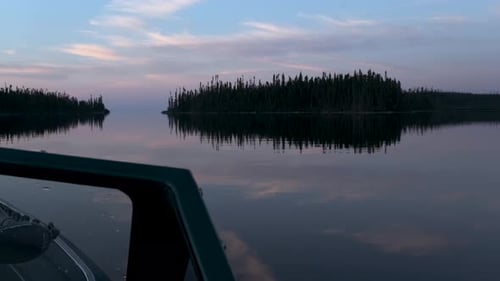 Fishing boat floating on a beautiful quite lake with a stunning evening sky