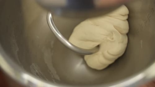 Bread Dough Preparation with Electric Mixer in Stainless Steel Bowl, Close Up