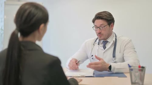 Male Doctor Talking with Female Patient in Clinic