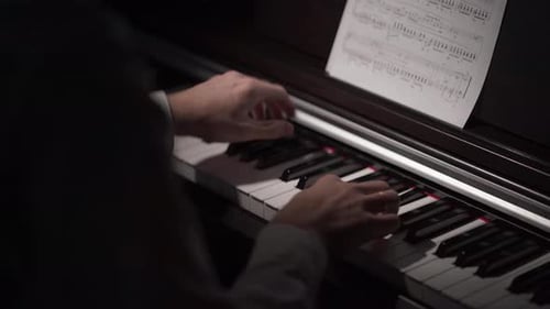 Musician Playing Piano Keys in Dark Room