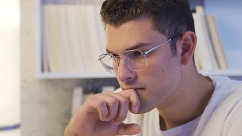 Young Man with Glasses Focused on Laptop