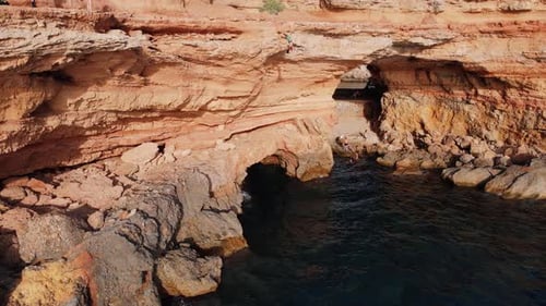 Mann mit Backflip Klippe springt in der Nähe von Sa Figuera Borda ins Meer mit Drohnenaufnahme aus der Luft an einem sonnigen Tag in I