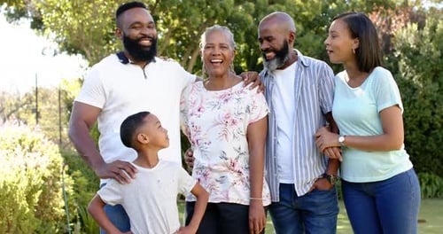 Smiling african american family posing together outdoors, enjoying quality time in garden